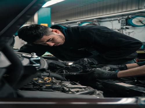Mécanicien de Access automobiles au travail sur un moteur